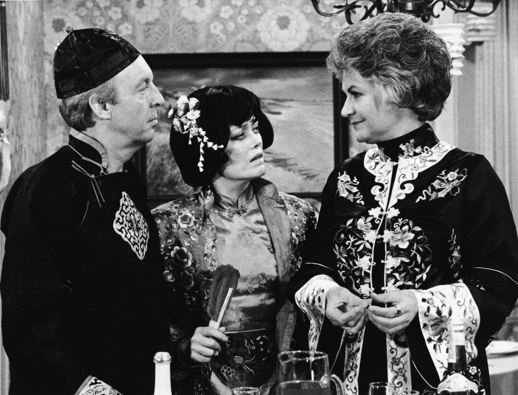 Image Credits: Getty Images / CBS Photo Archive | L-R: Actors Conrad Bain, Rue McLanahan and Beatrice Arthur wear Asian costumes in a still from the TV series, 'Maude,' 1978. Image Credits: Getty Images / CBS Photo Archive | L-R: Actors Conrad Bain, Rue McLanahan and Beatrice Arthur wear Asian costumes in a still from the TV series, 'Maude,' 1978.
