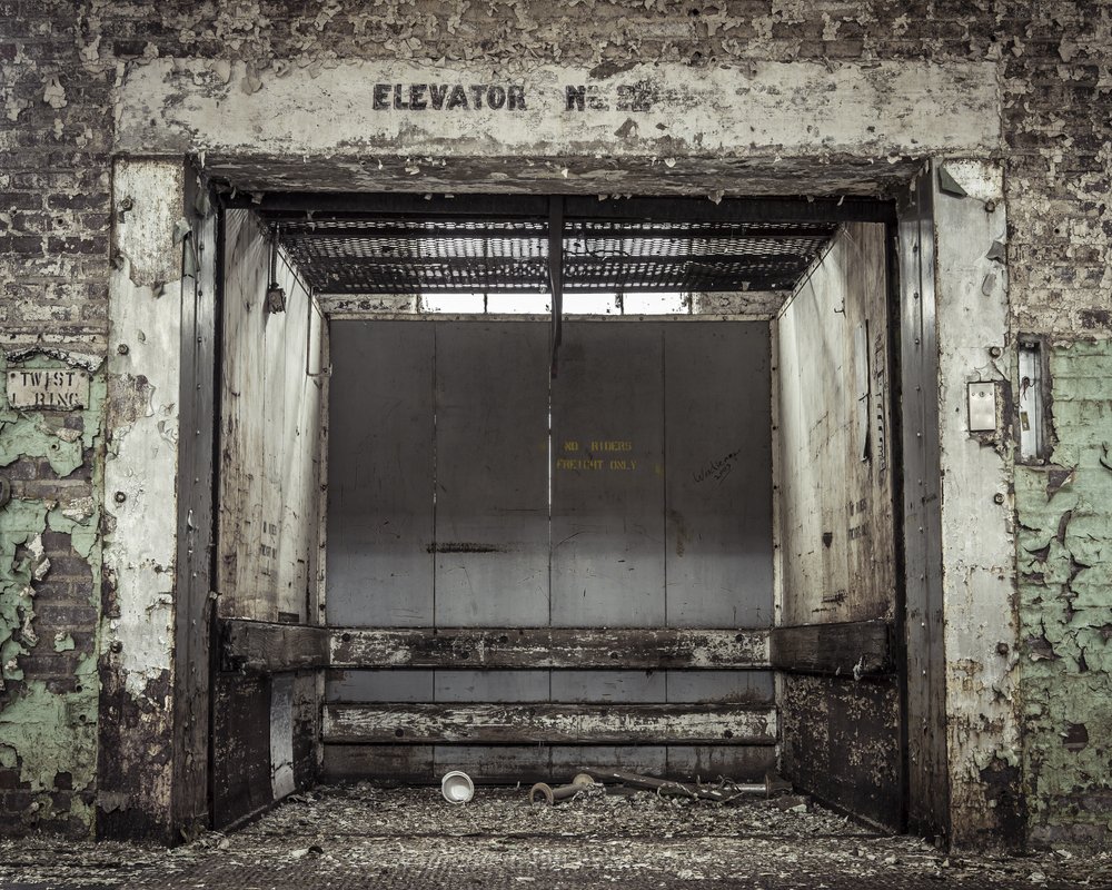 Grungy industrial elevator in an abandoned building | Shutterstock