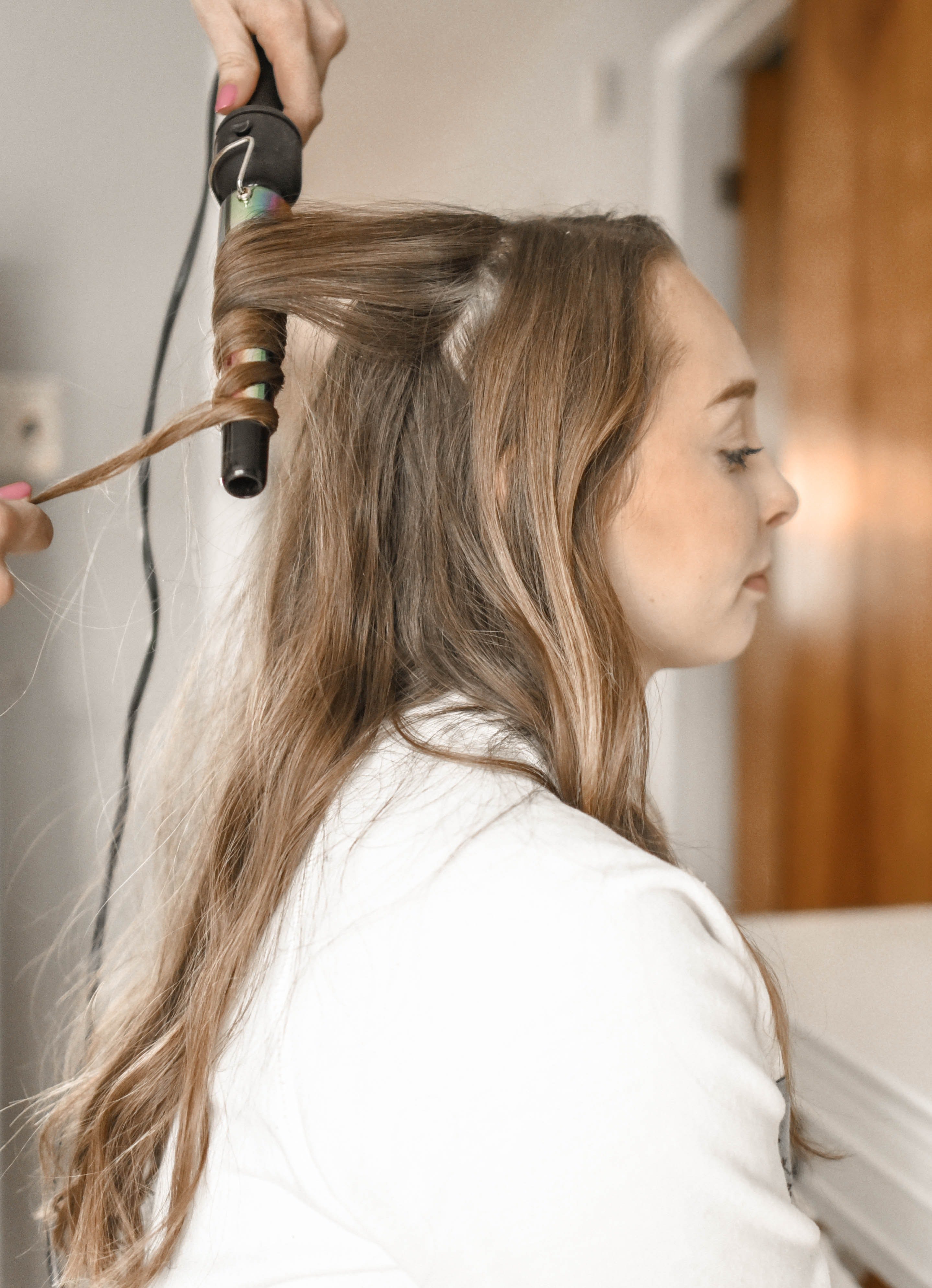 Woman curling her hair | Photo by Element5 Digital from Pexels