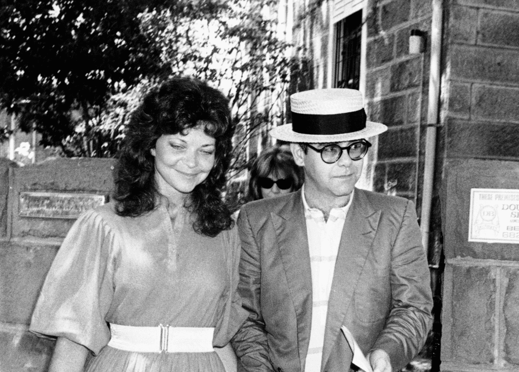 Image Credit: Getty Images / Renate Blauel and singer Elton John are seen outside St Mark's rectory two days before their wedding February 12, 1984 in Sydney, Australia.
