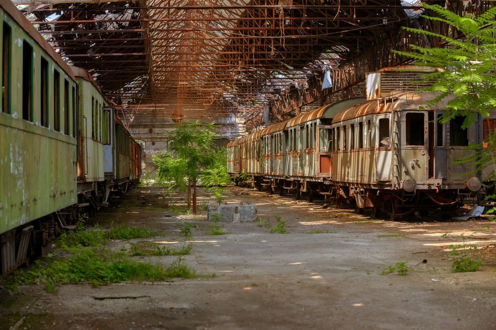 Cargo trains in old train depot eaten by rust | Shutterstock Cargo trains in old train depot eaten by rust | Shutterstock