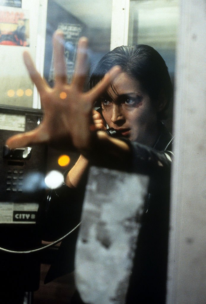 Image Credits: Getty Images / Warner Brothers | Carrie-Anne Moss in phone booth in a scene from the film 'The Matrix', 1999.