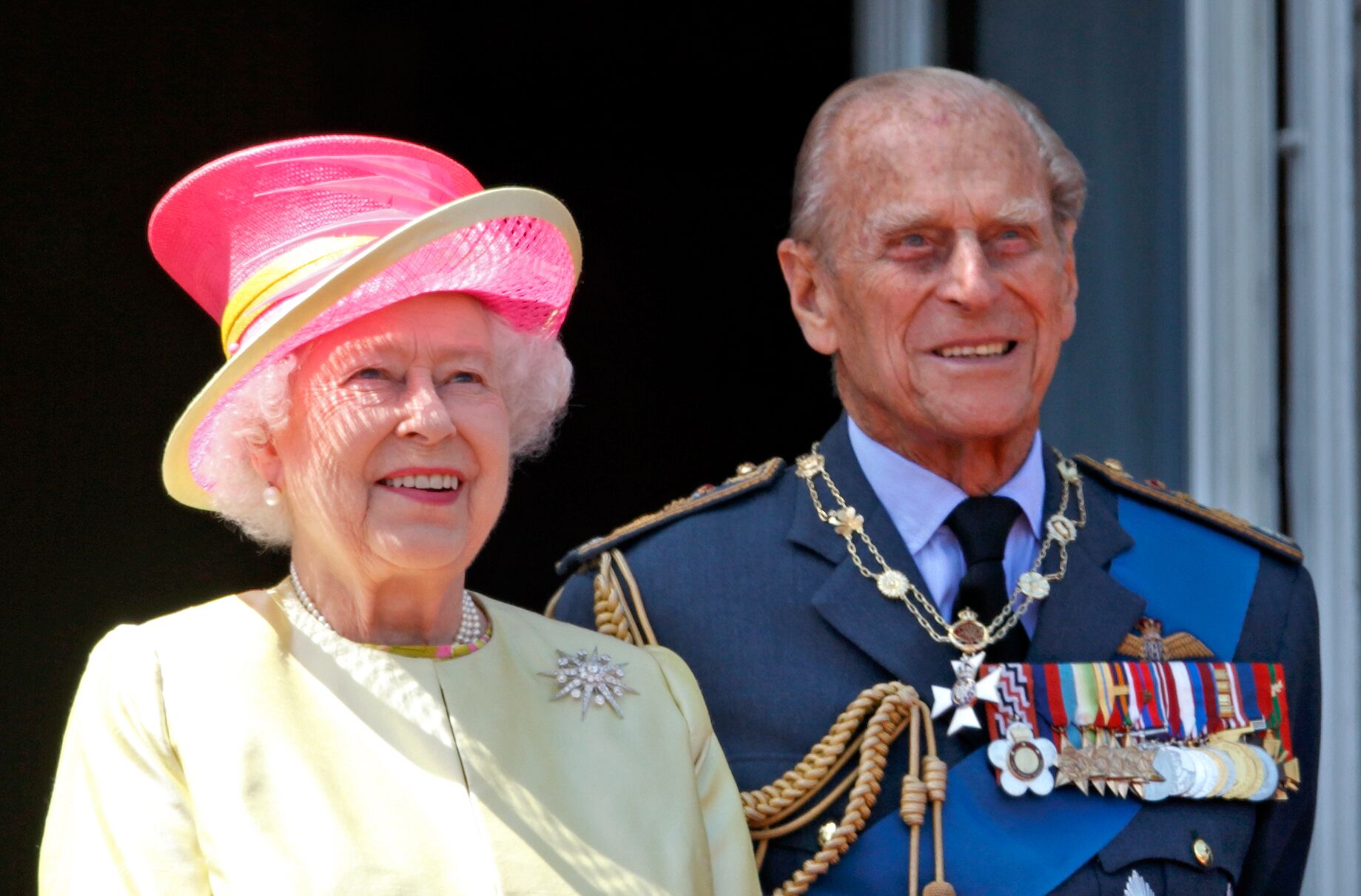 Queen Elizabeth II and Prince Philip, Duke of Edinburgh watch a flypast of Spitfire & Hurricane aircraft from the balcony of Buckingham Palace. | Source: Getty Images