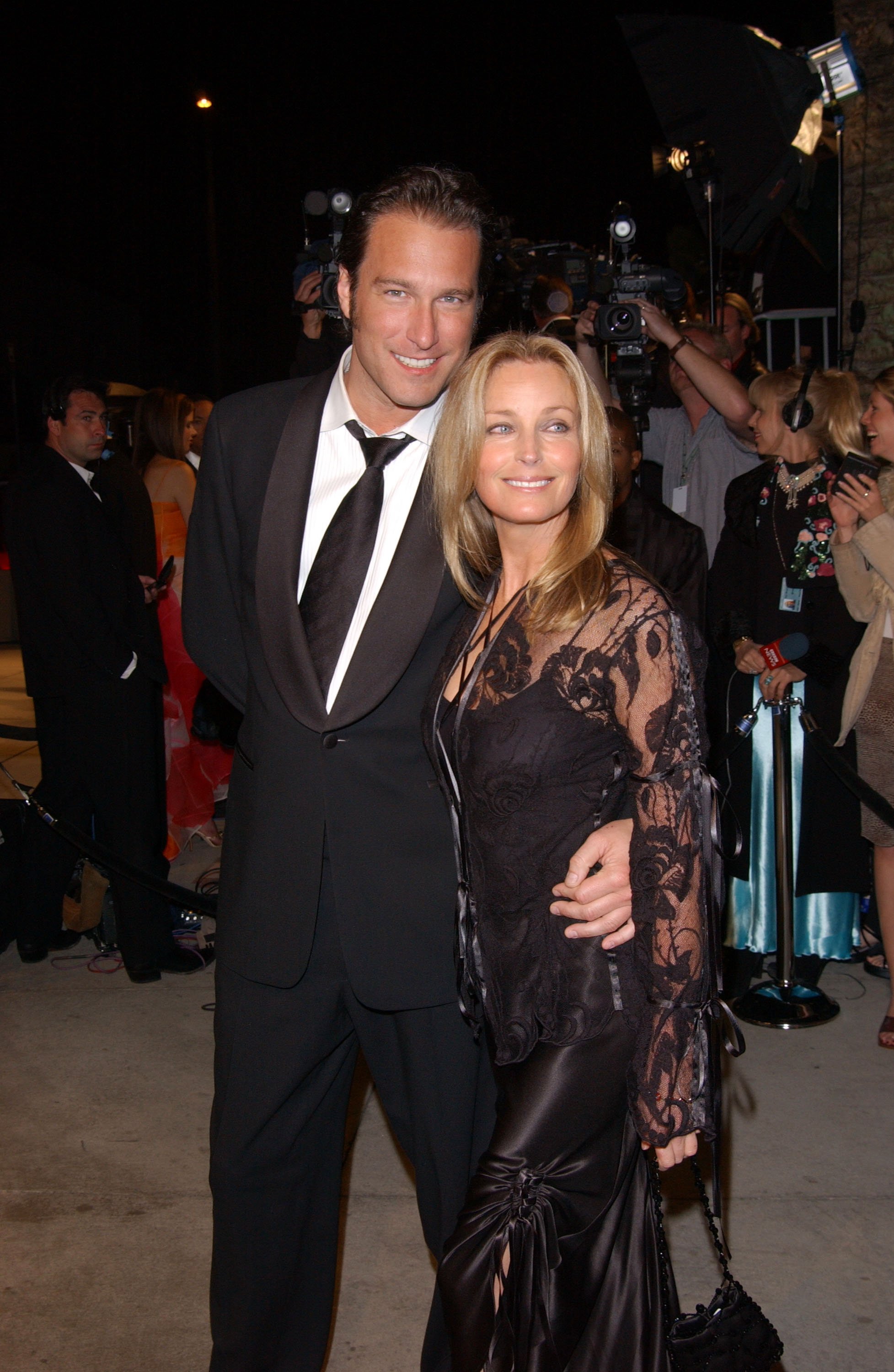 Image Credits: Getty Images / The model and Hollywood actor Bo Derek and John Corbett are photographed by the press.