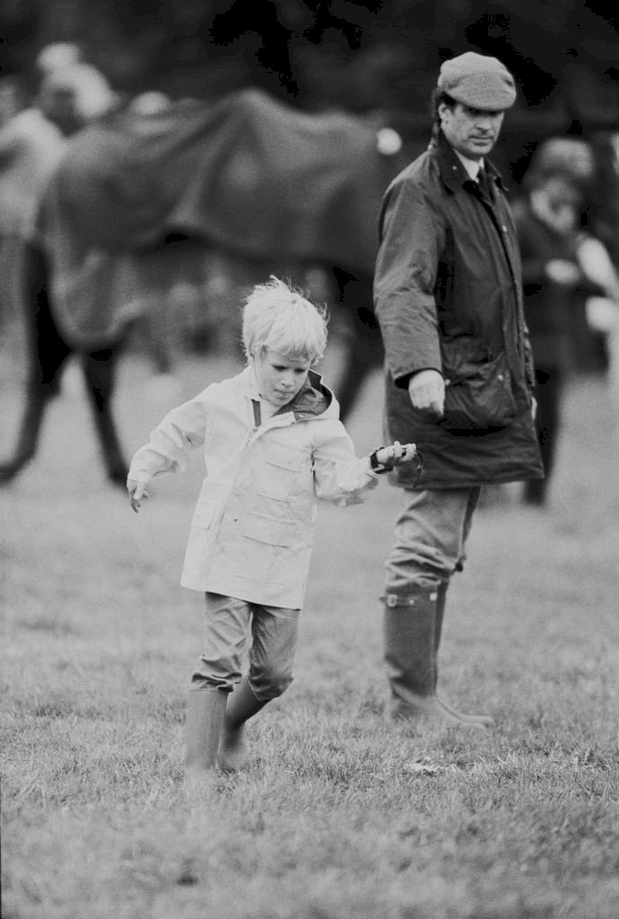 Image Credits: Getty Images / Trott / Daily Express / Hulton Archive | English Olympic gold-medal-winning horseman Mark Phillips with his son Peter Phillips, UK, 11th September 1983. Image Credits: Getty Images / Trott / Daily Express / Hulton Archive | English Olympic gold-medal-winning horseman Mark Phillips with his son Peter Phillips, UK, 11th September 1983.