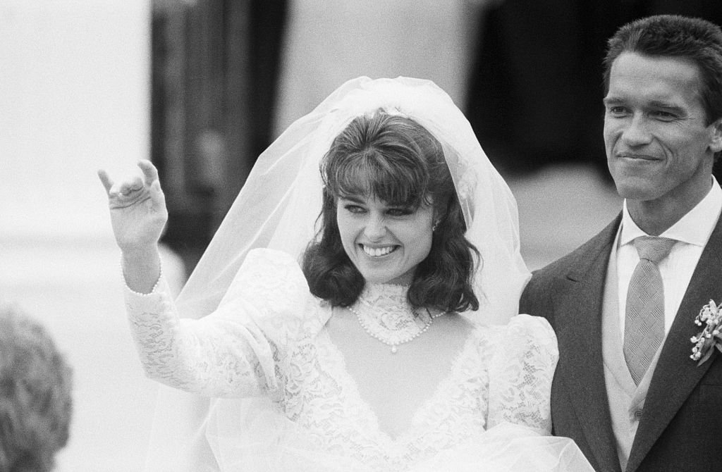 Image Credits: Getty Images / Nancy Lane | Smiling Maria Shriver Schwarzenegger and her new husband Arnold Schwarzenegger acknowledge well-wishers in front of St. Francis Xaviers Church in Hyannis after their wedding ceremony. Image Credits: Getty Images / Nancy Lane | Smiling Maria Shriver Schwarzenegger and her new husband Arnold Schwarzenegger acknowledge well-wishers in front of St. Francis Xaviers Church in Hyannis after their wedding ceremony.