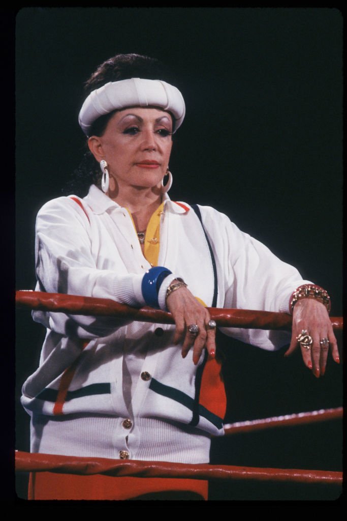 Image Credits: Getty Images / Laura Luongo / Liaison | Jacqueline Stallone stands in the ring May 4, 1988 in Los Angeles, CA. Stallone manages the all-female wrestling team GLOW Girls (Gorgeous Ladies Of Wrestling) which has achieved fame through their use of colorful costumes and elegant acrobatics.
