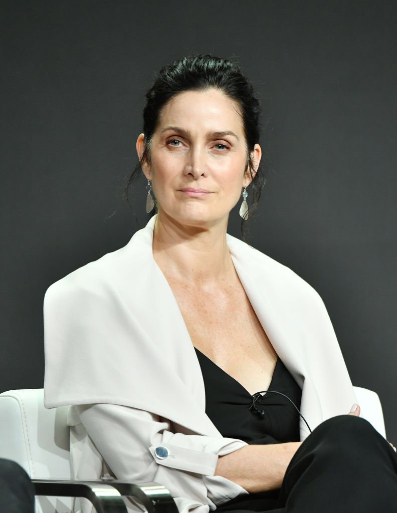 Image Credits: Getty Images / Amy Sussman | Carrie-Anne Moss of "Tell Me A Story" speaks during the CBS segment of the 2019 Summer TCA Press Tour at The Beverly Hilton Hotel on August 1, 2019 in Beverly Hills, California.