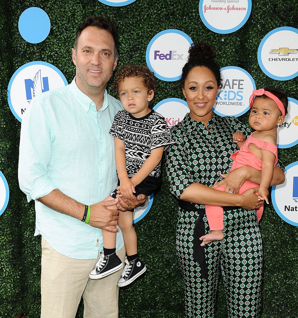 Image Credits: Getty Images / Jason LaVeris / FilmMagic | Adam Housley, Aden John Tanner Housley, Tamera Mowry and Ariah Talea Housley attend Safe Kids Day at Smashbox Studios on April 24, 2016 in Culver City, California.