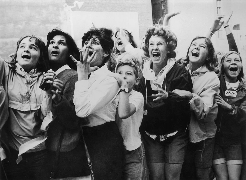 Image Credits: Getty Images / Fox Photos | Women and girls in Toronto, Canada screaming with joy during a visit by the Beatles to their city.