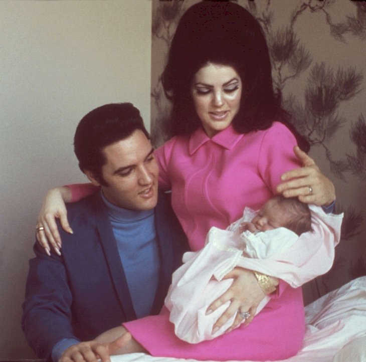 Image Credit: Getty Images / Rock and roll singer Elvis Presley with his wife Priscilla Beaulieu Presley and their 4 day old daughter Lisa Marie Presley.