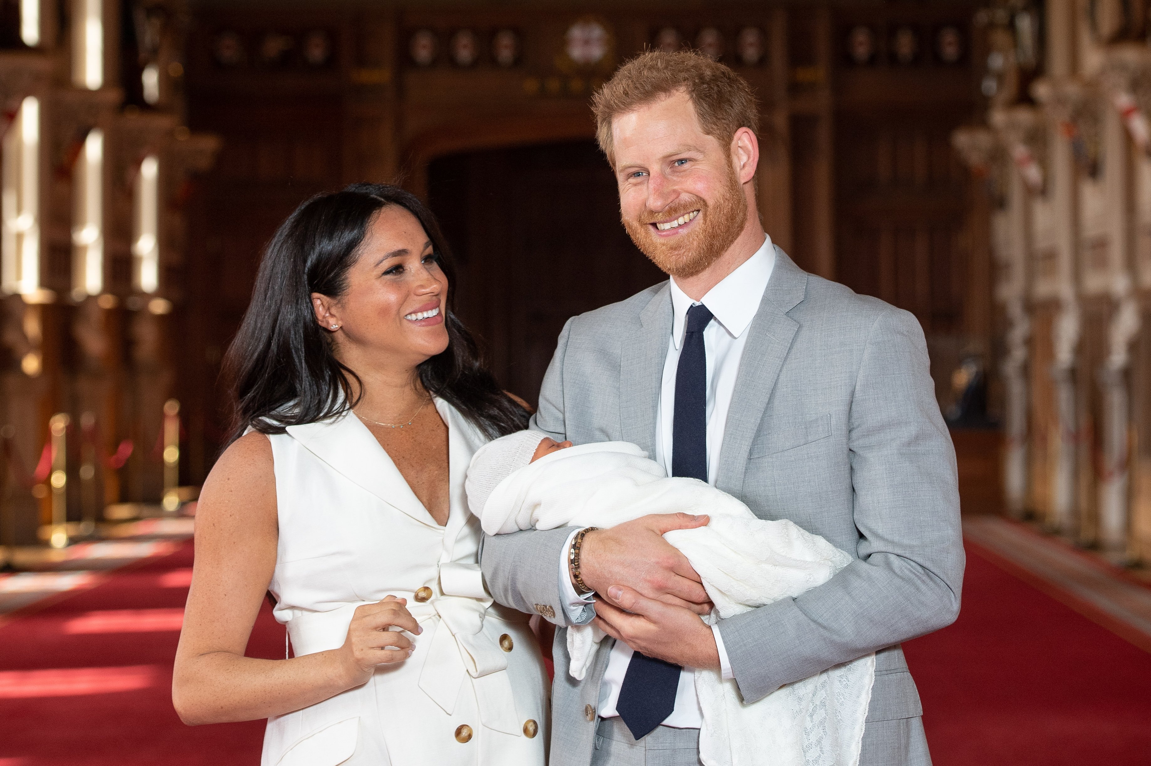 Image Credits: Getty Images / Dominic Lipinski - WPA Pool | Prince Harry, Duke of Sussex and Meghan, Duchess of Sussex, pose with their newborn son Archie Harrison Mountbatten-Windsor during a photocall in St George's Hall at Windsor Castle on May 8, 2019 in Windsor, England. The Duchess of Sussex gave birth at 05:26 on Monday 06 May, 2019.