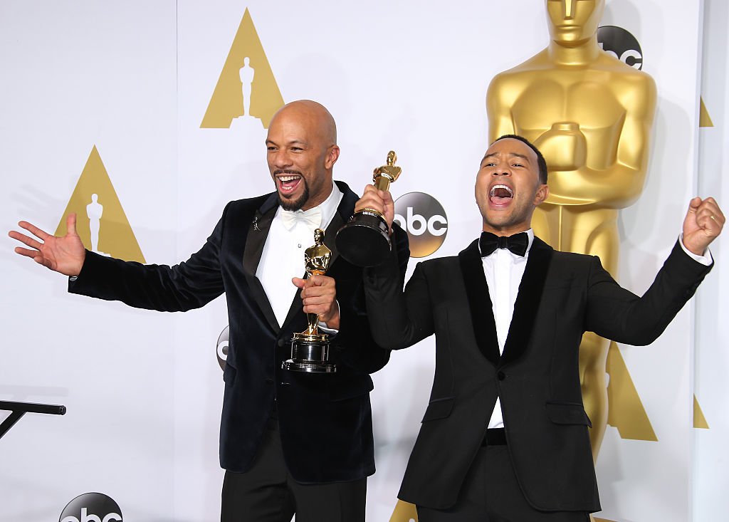 Image Credits: Getty Images / Dan MacMedan/WireImage | Common and John Legend pose in the press room with their awards for Best Original Song