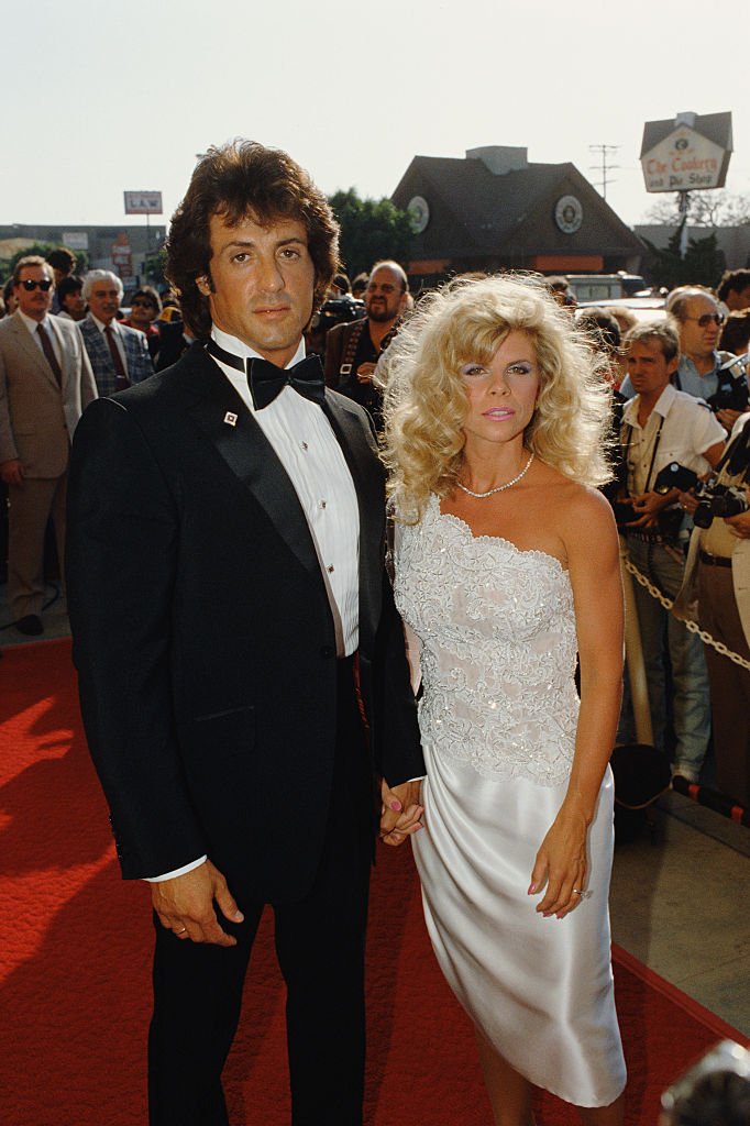 Image Credits: Getty Images / Bill Nation / Sygma | American actor, director, screenwriter and producer Sylvester Stallone and his wife Sasha Czack attend the premiere of the movie Rhinestone, directed by Bob Clark.