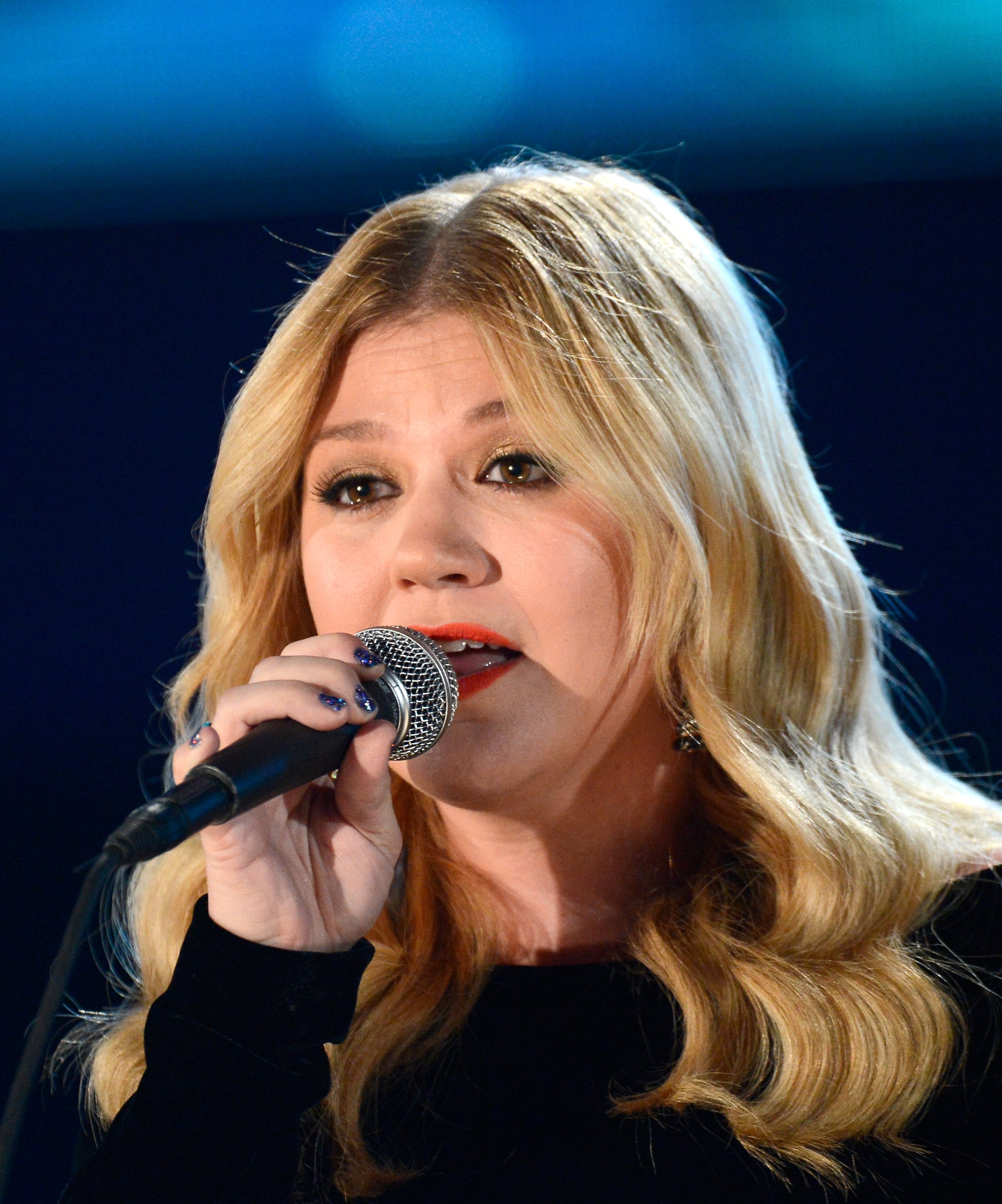 Image Source: Getty Images | Kelly singing at an event