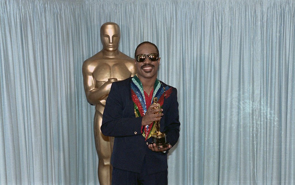 Image Credits: Getty Images / Bettmann | Stevie Wonder holding his Oscar