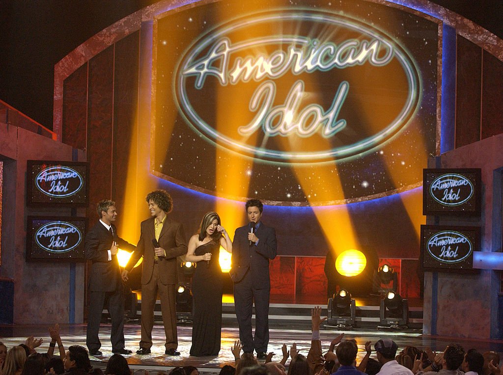 Image Credit: Getty Images / American Idol contestants Justin Guarini, Kelly Clarkson with host Ryan Seacrest & Brian Dunkleman. Image Credit: Getty Images / American Idol contestants Justin Guarini, Kelly Clarkson with host Ryan Seacrest & Brian Dunkleman.