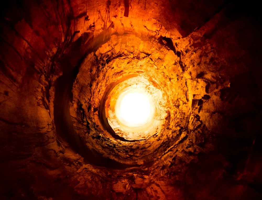 Red and yellow tunnel leading to the rotating light. | Shutterstock