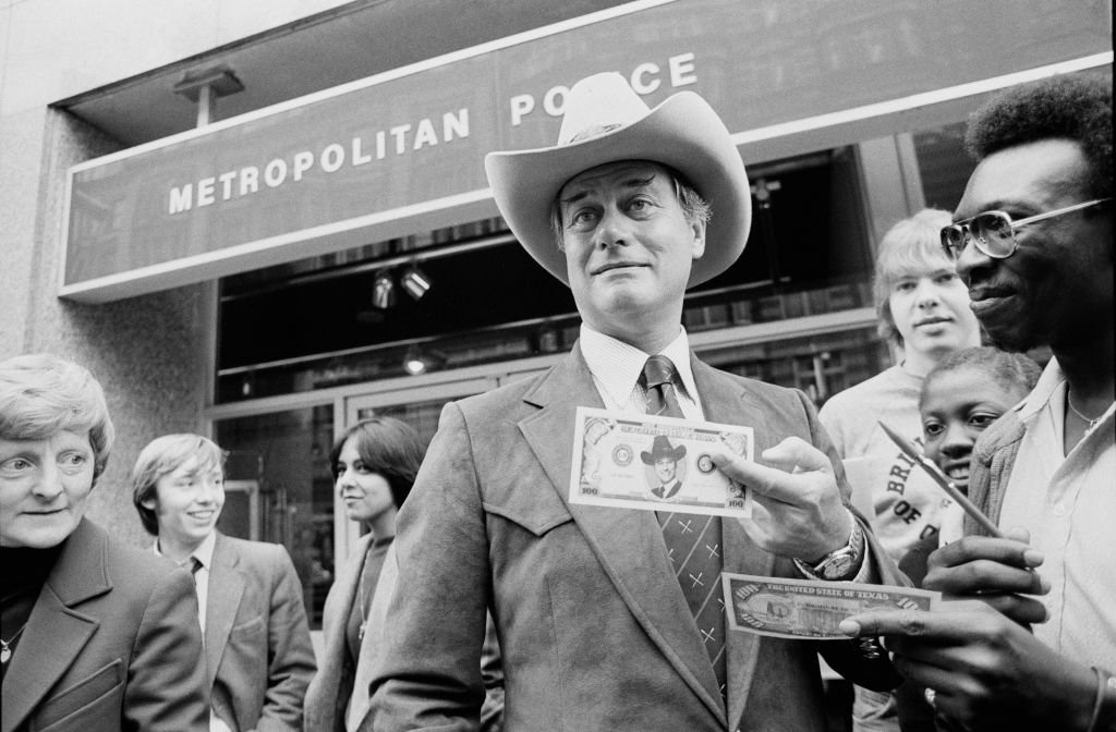 Image Credit: Getty Images / Larry Hagman, American actor and star of soap opera 'Dallas', signs a $100 bill.