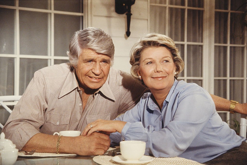 Image Credit: Getty Images / American actors Jim Davis (1909 - 1981) and Barbara Bel Geddes, as John Ross 'Jock' Ewing and Eleanor Southworth 'Miss Ellie' Ewing, sit at a table.