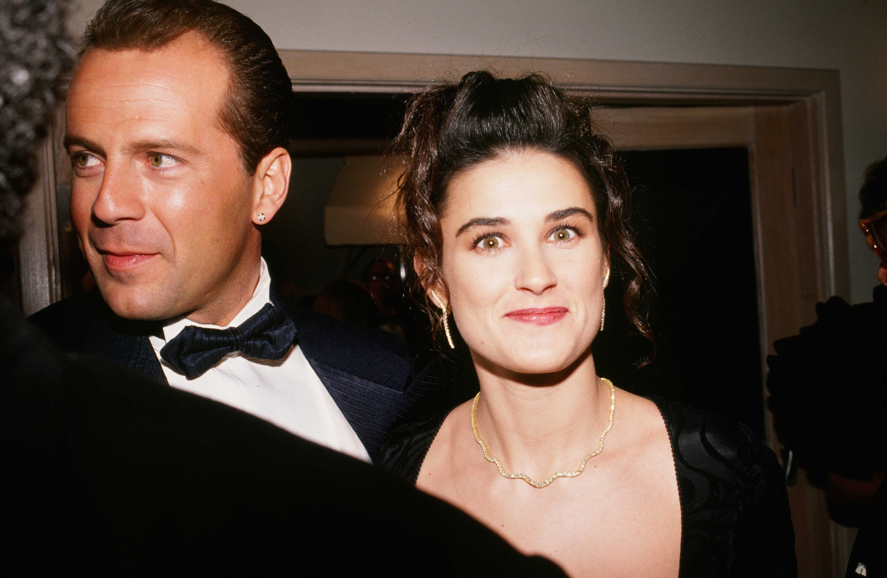 Image Credits: Getty Images / George Rose | Actors Bruce Willis and Demi Moore arrive at the 1989 West Hollywood, California, Irving "Swifty" Lazar Oscar Party held at Spago.