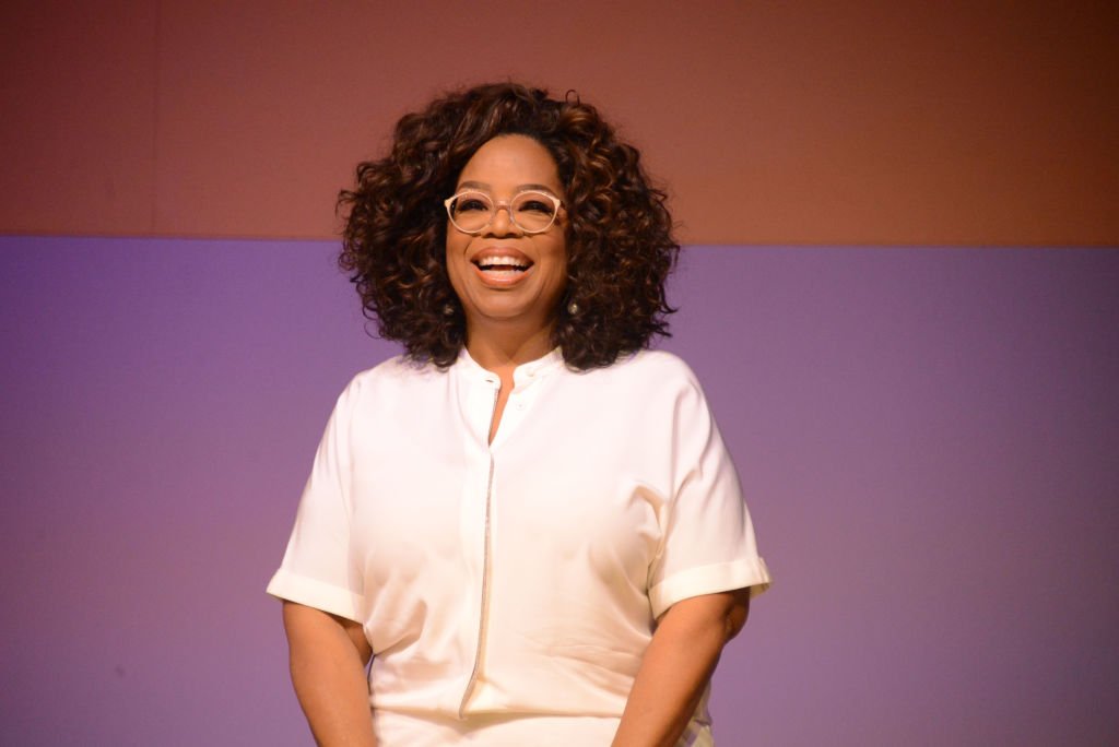 Image Credit: Getty Images / Oprah Winfrey waves during the Nelson Mandela Foundations Isthunzi Sabafazi The Dignity of Women conversation at the University of Johannesburgs (UJ) Soweto Campus on November 29, 2018.