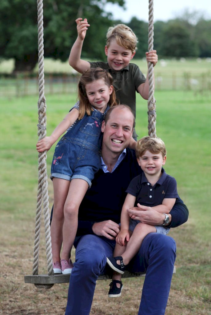 Image Credit: Getty Images / The Duke of Cambridge poses on a swing with Prince George, Princess Charlotte and Prince Louis.
