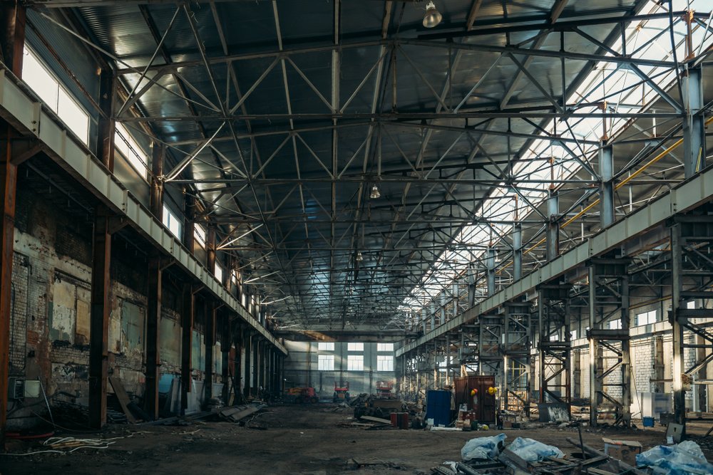 Ruined industrial hall of warehouse or hangar in process of reconstruction | Shutterstock