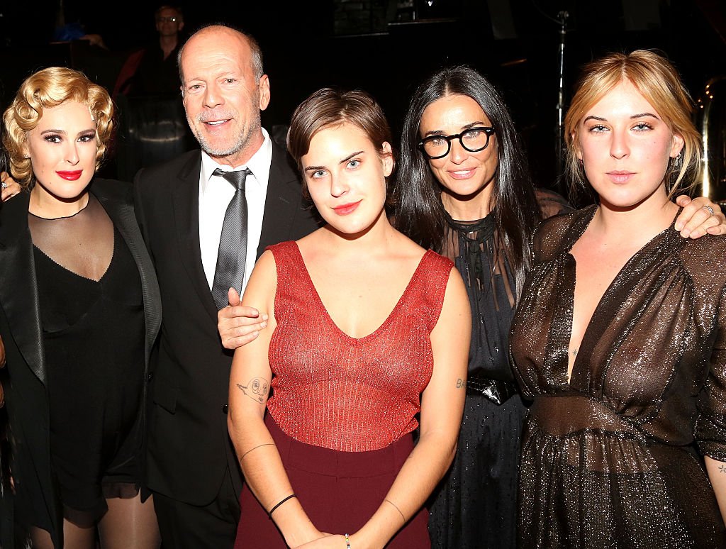 Image Credits: Getty Images / Bruce Glikas / FilmMagic | (L-R) Rumer Willis, father Bruce Willis, sister Tallulah Belle Willis, mother Demi Moore and sister Scout LaRue Willis pose backstage as Rumer makes her broadway debut as "Roxie Hart" in Broadway's "Chicago" on Broadway at The Ambassador Theater on September 21, 2015 in New York City.