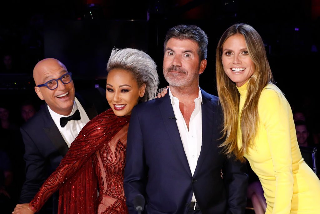 Image Credit: Getty Images / America's Got Talent, Season 12 with judges Howie Mandel, Mel B, Heidi Klum, Simon Cowell.
