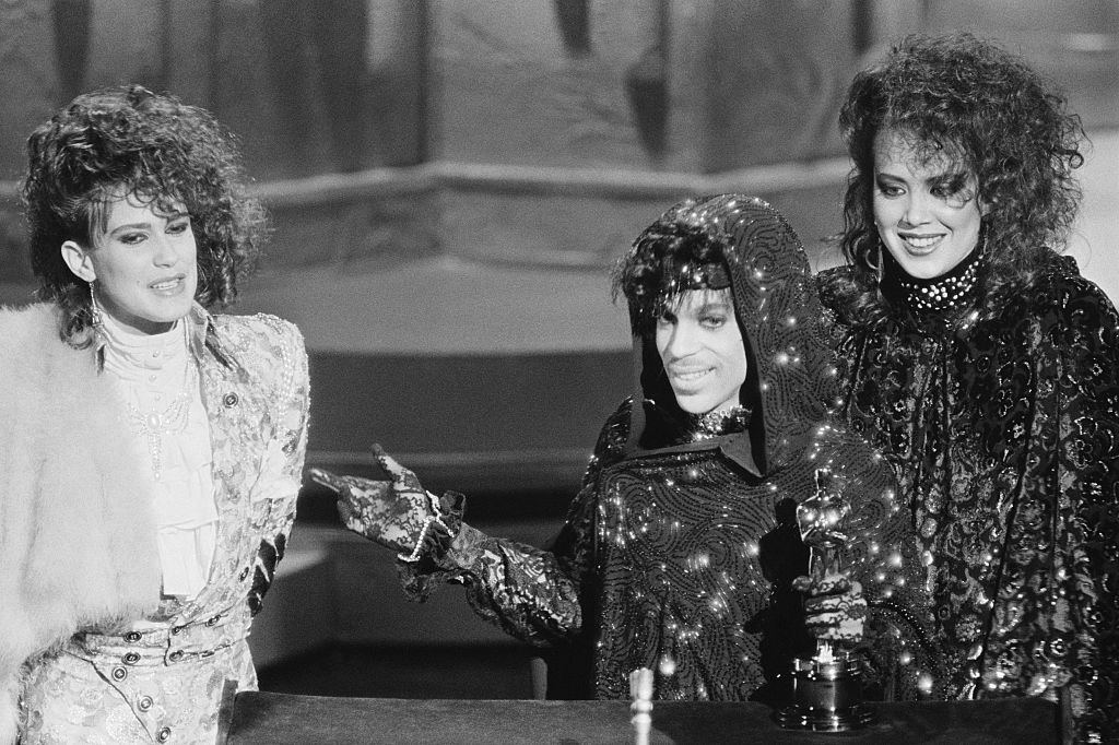 Image Credits: Getty Images / Bettmann | Prince and members of his group accept their Oscar for Best Original Song Score for "Purple Rain."