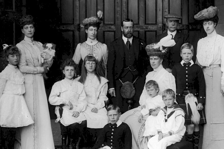 Image Credits: Getty Images / W. and D. Downey / Hulton Archive | Members of the British royal family at Balmoral, circa 1905. Standing, left to right: Princess Mary (1897 - 1965), Queen Alexandra (1844 - 1925), Princess Louise, Duchess Of Fife (1867 - 1931), George, Prince of Wales (later King George V, 1865 - 1936), Alexander Duff, Duke of Fife (1840 - 1912), Edward, Duke of Windsor (1894-1972) (later King Edward VIII) and Princess Victoria (1868 - 1935). Seated, left to right: the daughters of the Duke and Duchess of Fife, George, Duke of York (later King George VI (1895 - 1952), Queen Mary (1867 - 1953), Prince George, Duke of Kent (1902 - 1942) and Prince Henry, Duke of Gloucester (1900 - 1974).