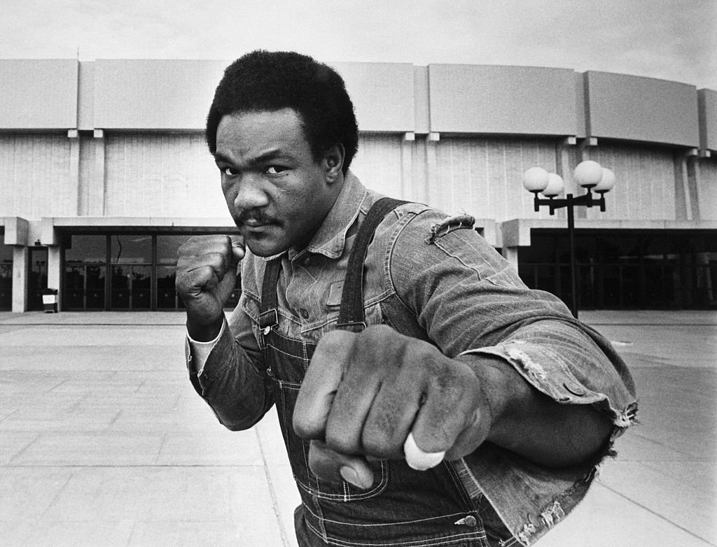 Image Source: Getty Images/Bettmann/Heavyweight contender George Foreman strikes a fighting pose in front of Nassau Coliseum here where he meets Joe Frazier in a 12-round bout