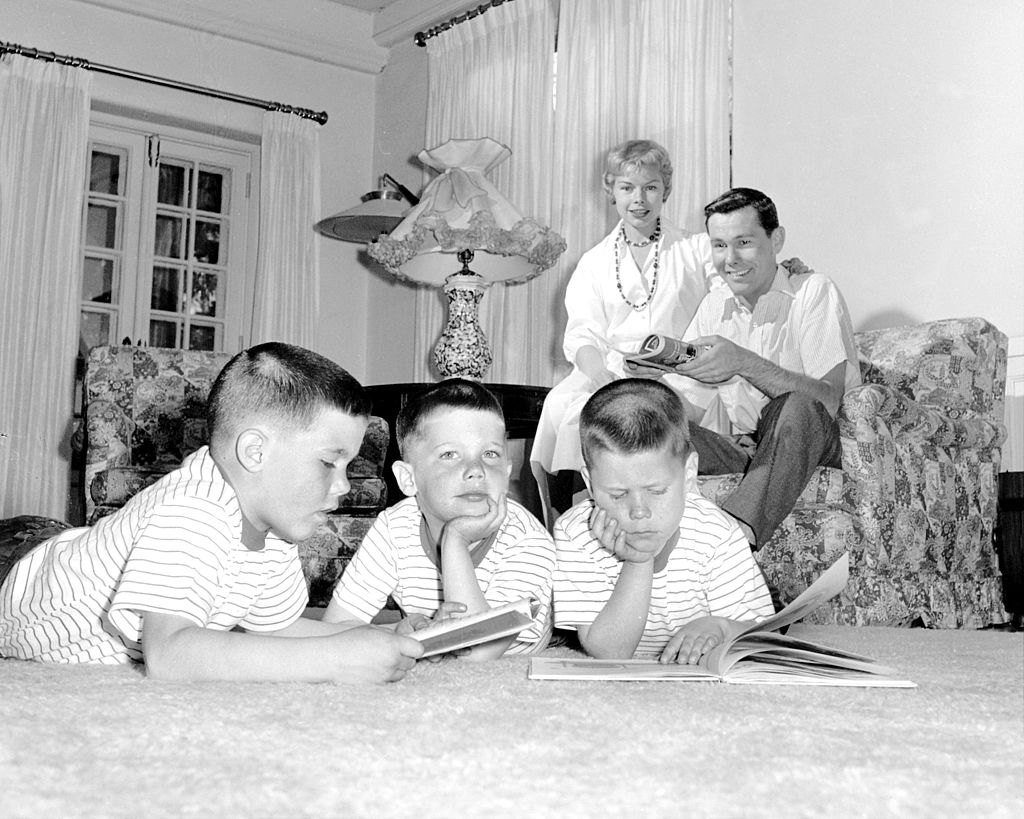 Image Credits: Getty Images / NY Daily News Archive | Johnny Carson and his family at his home, Birch Hill Estate, Winfield Ave, Harrison, N.Y. Cory Carson, 4, is wrapped in his own thoughts as parents relax, brothers Kit (left) and Ricky (right) leaf through picture books.