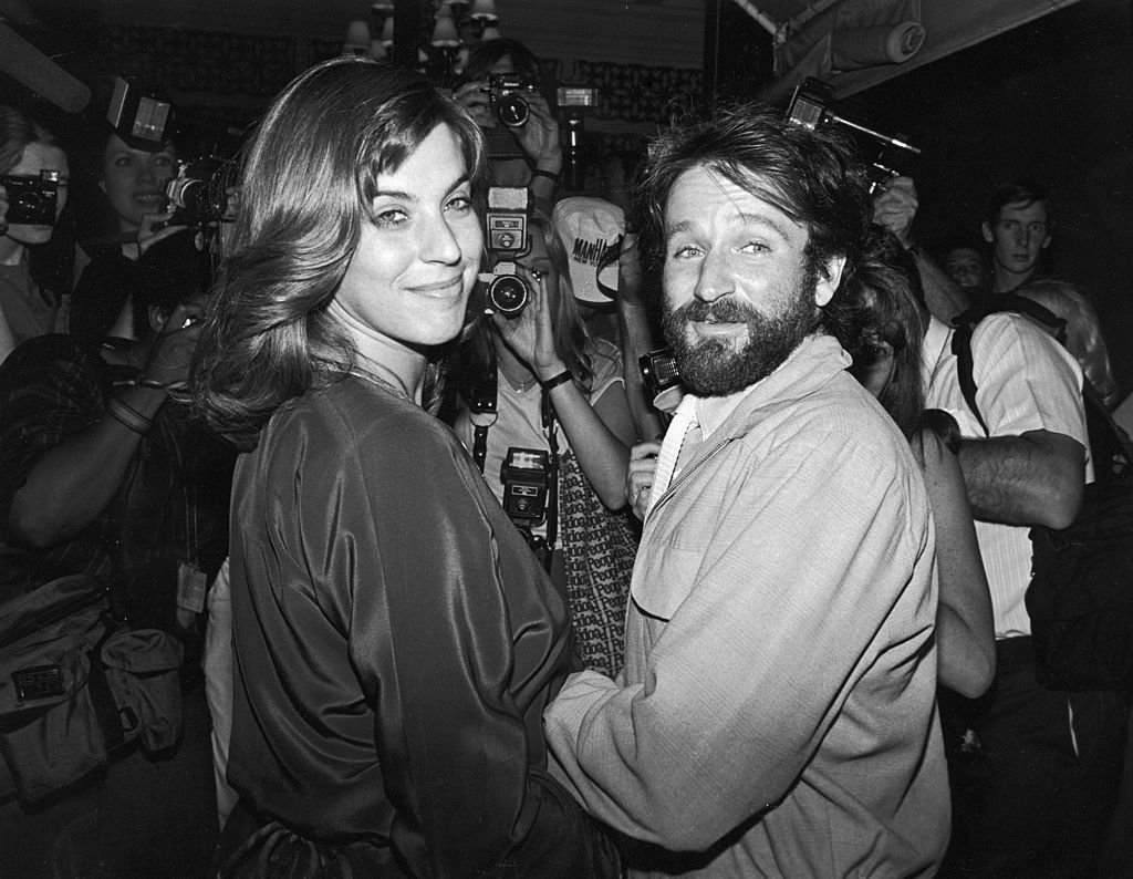 Image Credits: Getty Images / David McGough / DMI / The LIFE Picture Collection | Valerie Velardi and her husband, American comedian and actor Robin Willimas, and a huge number of photographers packed into singer Paul Simon's apartment to celebrate the singer's wedding to actress Carrie Fisher, New York, New York, August 16, 1983.