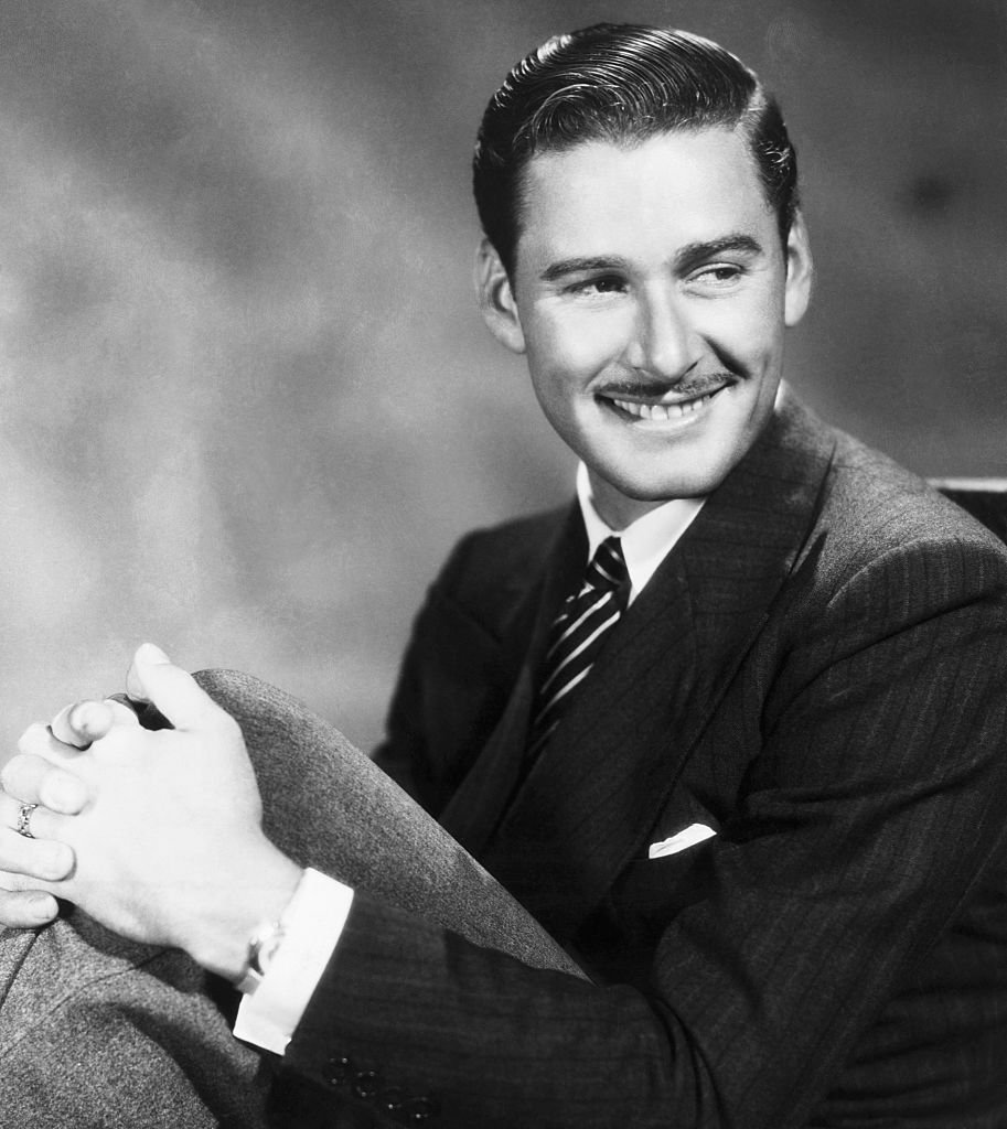 Image Source: Getty Images/Bettmann/Portait of actor Errol Flynn (1909-1959), with his hands around his knees