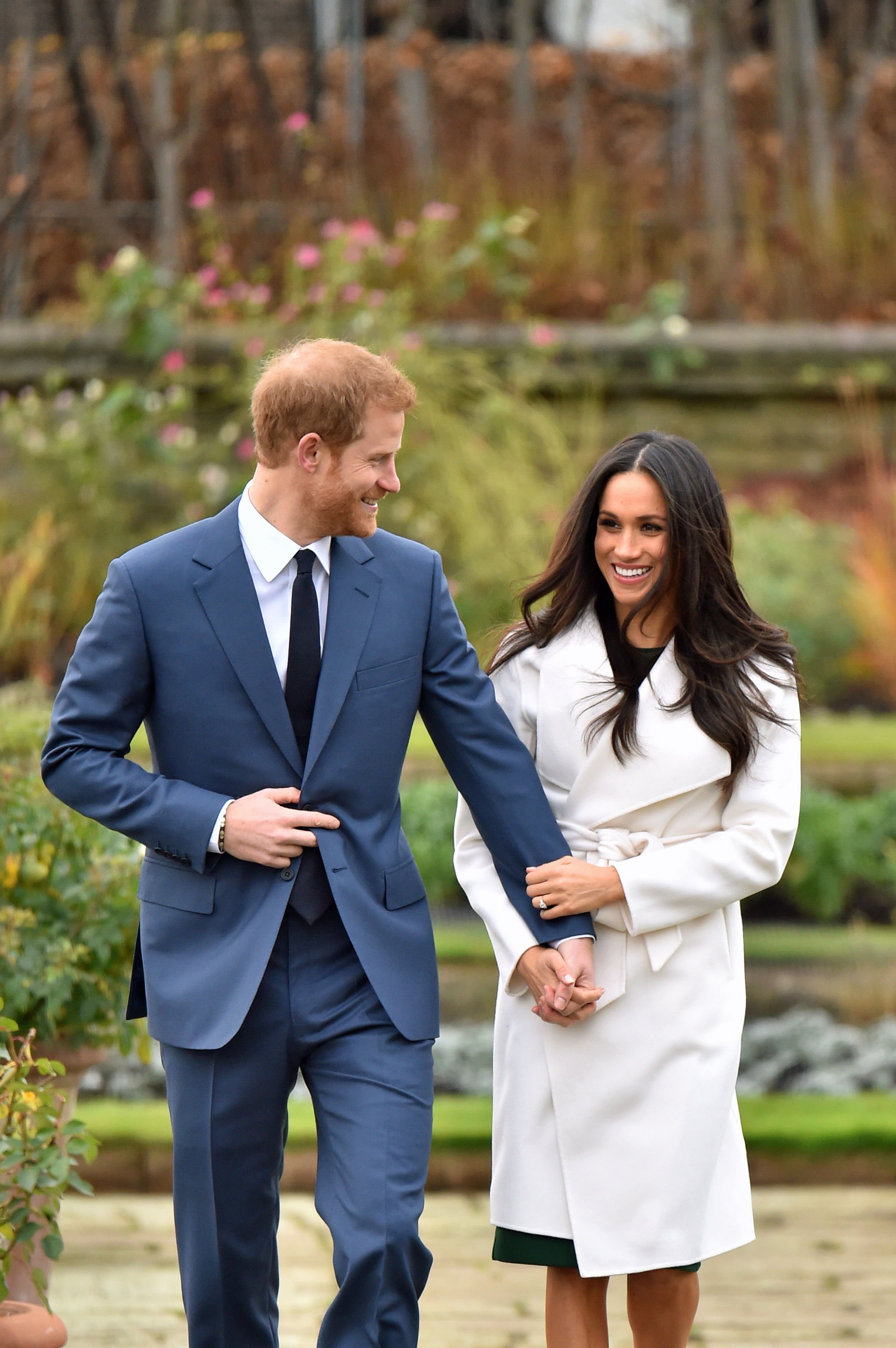 Image Credits: Getty Images / Dominic Lipinski / PA Images | Prince Harry and Meghan Markle in the Sunken Garden at Kensington Palace, London, after the announcement of their engagement.