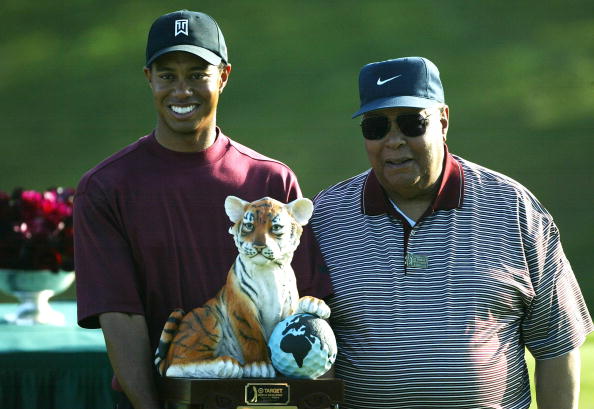 Image Credits: Getty Images / Doug Benc | Tiger Woods (L) stands with his father, Earl Woods, during the trophy presentation of the Target World Challenge on December 12, 2004 at Sherwood Country Club in Thousand Oaks, California. Woods won the event at 16 under par. Image Credits: Getty Images / Doug Benc | Tiger Woods (L) stands with his father, Earl Woods, during the trophy presentation of the Target World Challenge on December 12, 2004 at Sherwood Country Club in Thousand Oaks, California. Woods won the event at 16 under par.