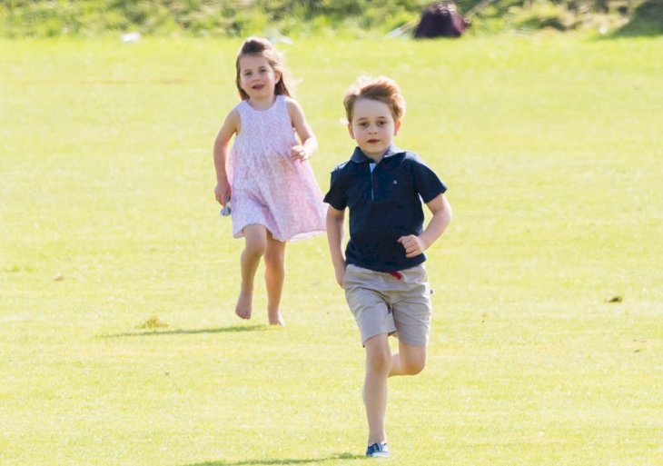 Image Credit: Getty Images / Prince George of Cambridge and Princess Charlotte of Cambridge run together during the Maserati Royal Charity Polo.