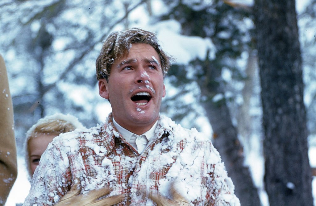 Image Source: Getty Images / Actor Errol Flynn is covered in snow after falling on his skies, as he is in town for the movie premiere of "Santa Fe Trail" in December 1940.