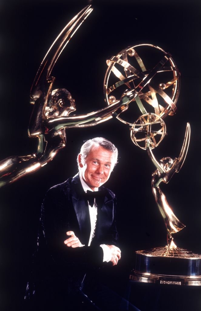 Image Credits: Getty Images / CBS Photo Archive | Television star and comedian Johnny Carson (1925 - 2005) dwarfed by two bronze awards, 1972.