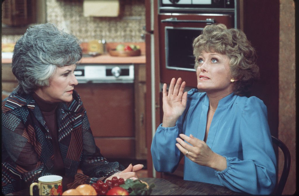 Image Credits: Getty Images / CBS Photo Archive | American actresses Beatrice Arthur (as Maude Findlay) (left) and Rue McClanahan (as Vivian Cavender Harmon) talk at a table in a scene from the television show 'Maude,' Los Angeles, California, mid 1970s. Image Credits: Getty Images / CBS Photo Archive | American actresses Beatrice Arthur (as Maude Findlay) (left) and Rue McClanahan (as Vivian Cavender Harmon) talk at a table in a scene from the television show 'Maude,' Los Angeles, California, mid 1970s.