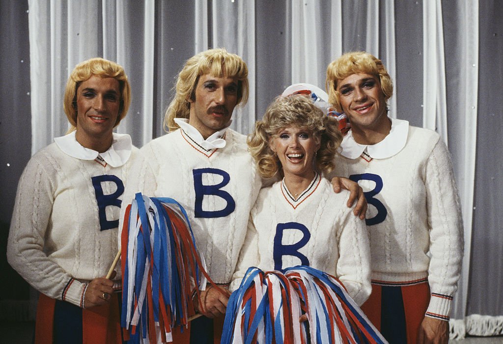 Image Credits: Getty Images / Richard Blanshard | The Hudson Brothers, Bill Hudson, Brett Hudson and Mark Hudson, dressed as cheerleaders for a sketch in the television comedy show 'Bonkers!', 1979.