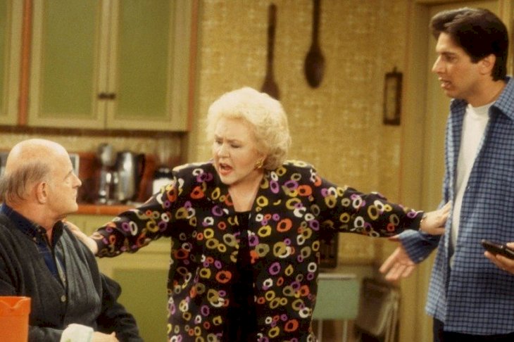 Image Credits: Getty Images / Everybody Loves Raymond actress Doris Roberts (center, as Marie Barone) separates actors Peter Boyle (as Frank Barone) and Ray Romano (as Ray Barone)