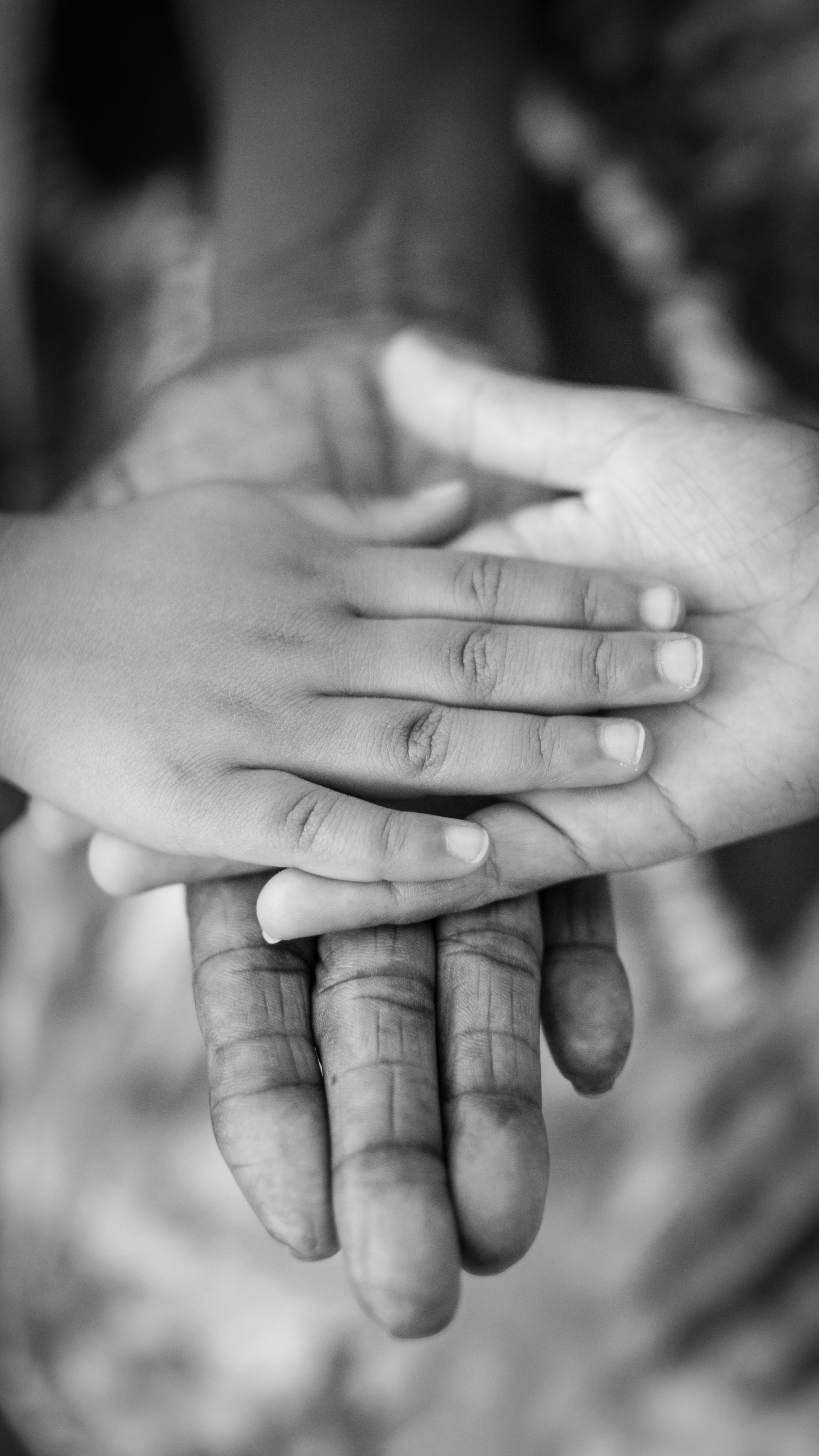 A child's hand on top of adult hands | Pexels
