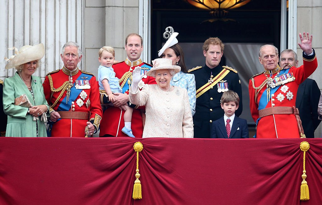 Image Credits: Getty Images / Chris Jackson | (L-R) Camilla, Duchess of Cornwall, Prince Charles, Prince of Wales, Prince George of Cambridge, Prince William, Duke of Cambridge, Catherine, Duchess of Cambridge, Queen Elizabeth II, Prince Harry and Prince Philip, Duke of Edinburgh (R) watch the fly-past from the balcony of Buckingham Palace following the Trooping The Colour ceremony on June 13, 2015 in London, England. The ceremony is Queen Elizabeth II's annual birthday parade and dates back to the time of Charles II in the 17th Century, when the Colours of a regiment were used as a rallying point in battle.