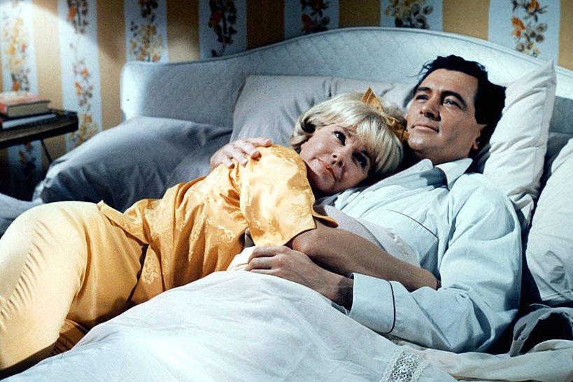 Image Credits: Getty Images / Universal | Doris Day lies in the arms of Rock Hudson in a scene from the film 'Send Me No Flowers', 1964.