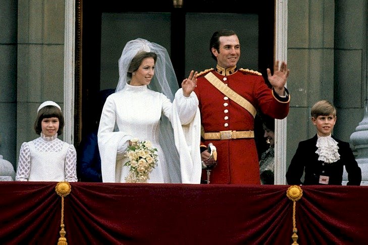 Image Credits: Getty Images / Anwar Hussein | Princess Anne, Princess Royal and Mark Phillips wave from the balcony of Buckingham Palace following their wedding with Prince Edward, Earl of Wessex (R) on November 14, 1973 in London, England. Image Credits: Getty Images / Anwar Hussein | Princess Anne, Princess Royal and Mark Phillips wave from the balcony of Buckingham Palace following their wedding with Prince Edward, Earl of Wessex (R) on November 14, 1973 in London, England.
