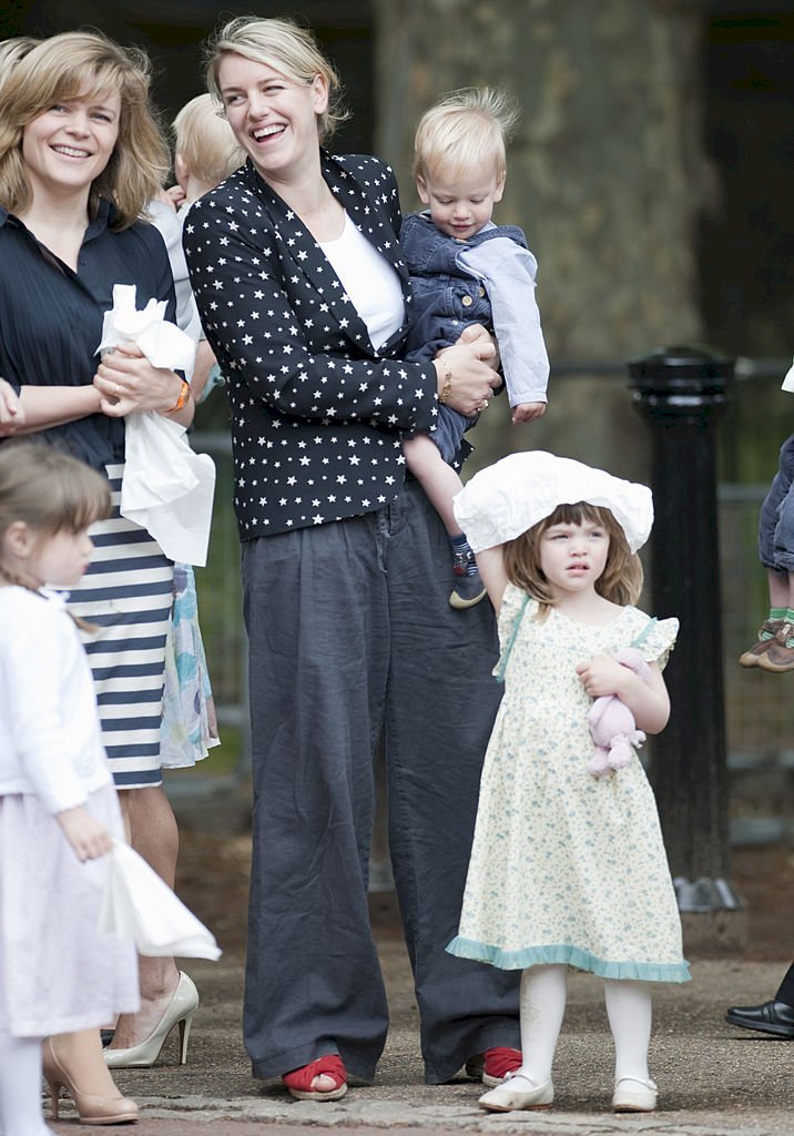 Image Credit: Getty Images/UK Press via Getty Images/Antony Jones | Laura holding on to Gus with Eliza at their side at the Trooping the Colour in 2011