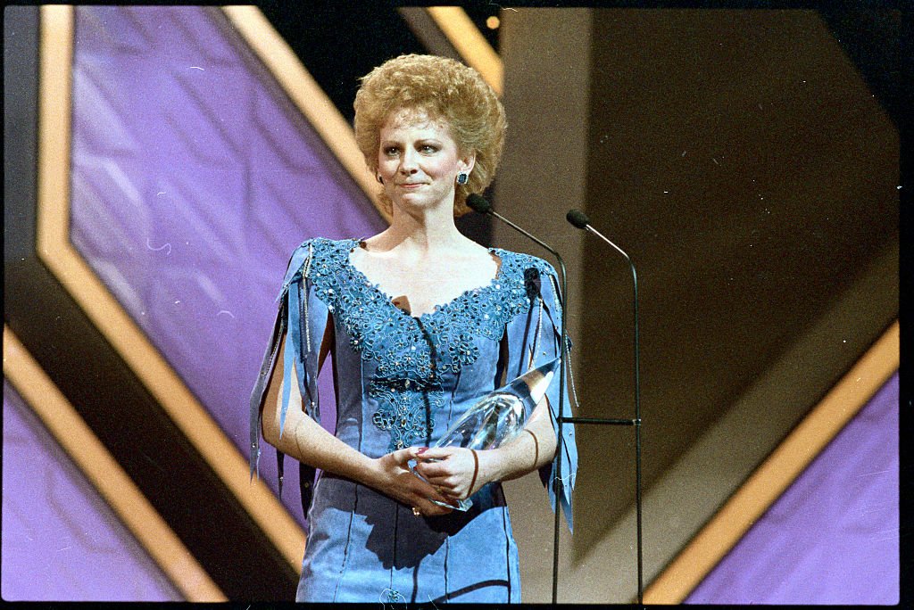 Image Credits: Getty Images / Bettmann | Reba receiving the award for "Entertainer of the Year"